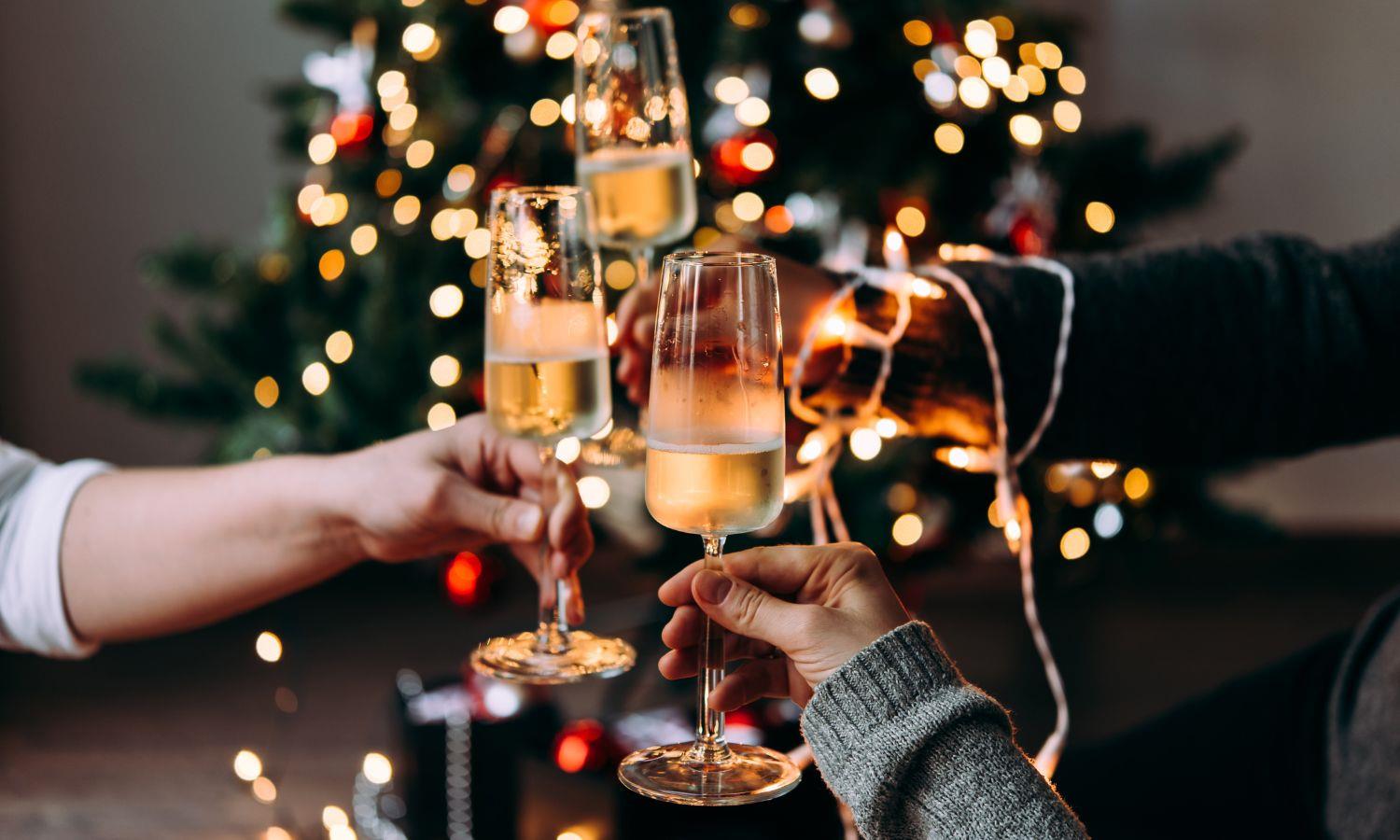Champagne glasses in a cheers with Christmas tree background