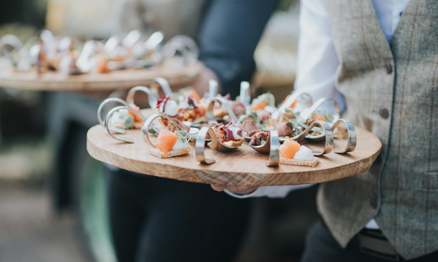 Waiter with circular tray of canapes
