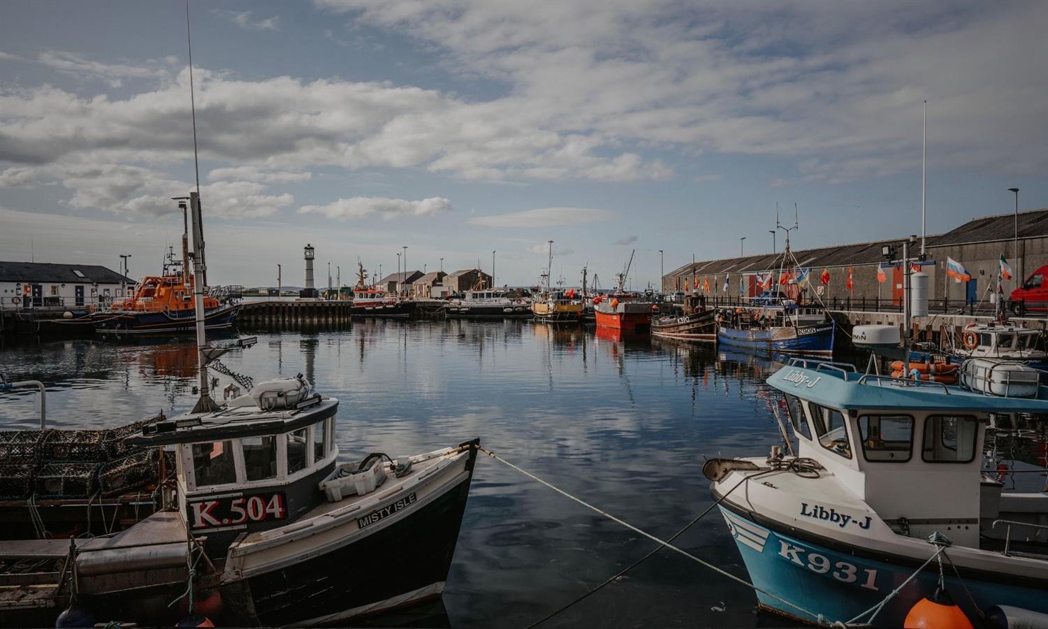 Boats moored at Kirkwall Harbour on a sunny day