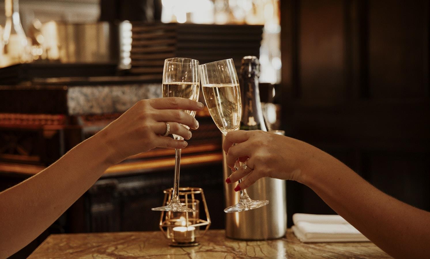 Two women clinking champagne flutes