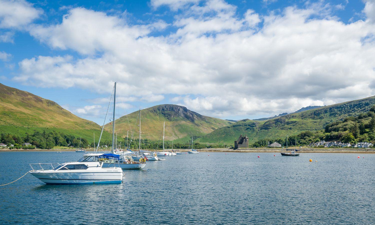 Boats moored in Loch Ranza with Lochranza Castle and mountain views on the Isle of Arran