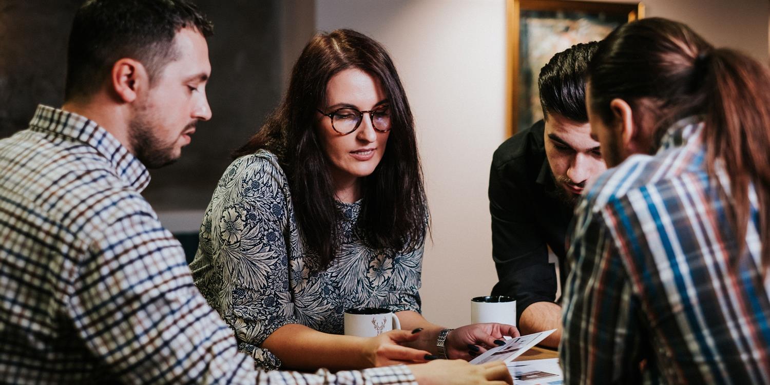 Four people at a table talking