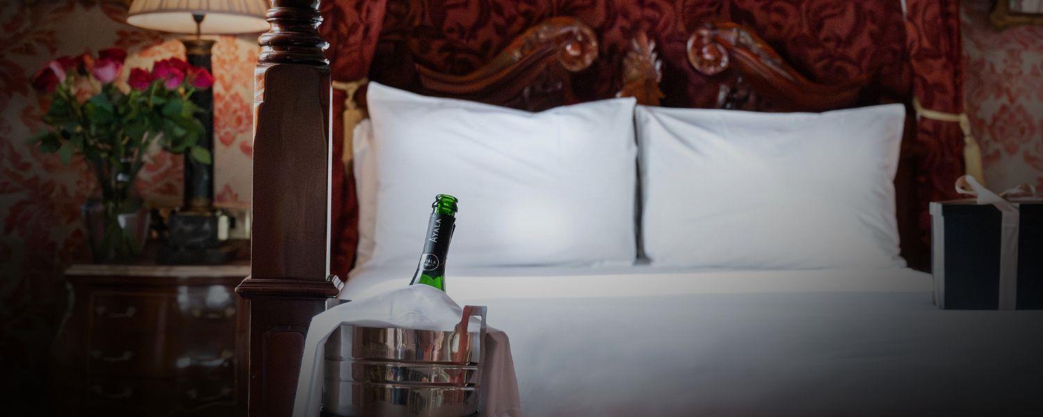 Luxury hotel bedroom with chilled bottle of Champagne