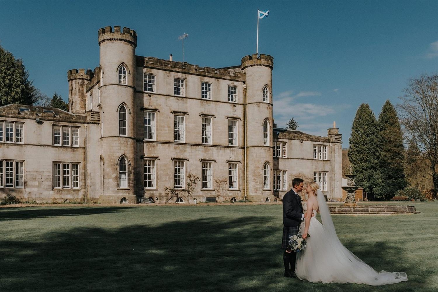 Bride and groom kissing outside Melville Castle