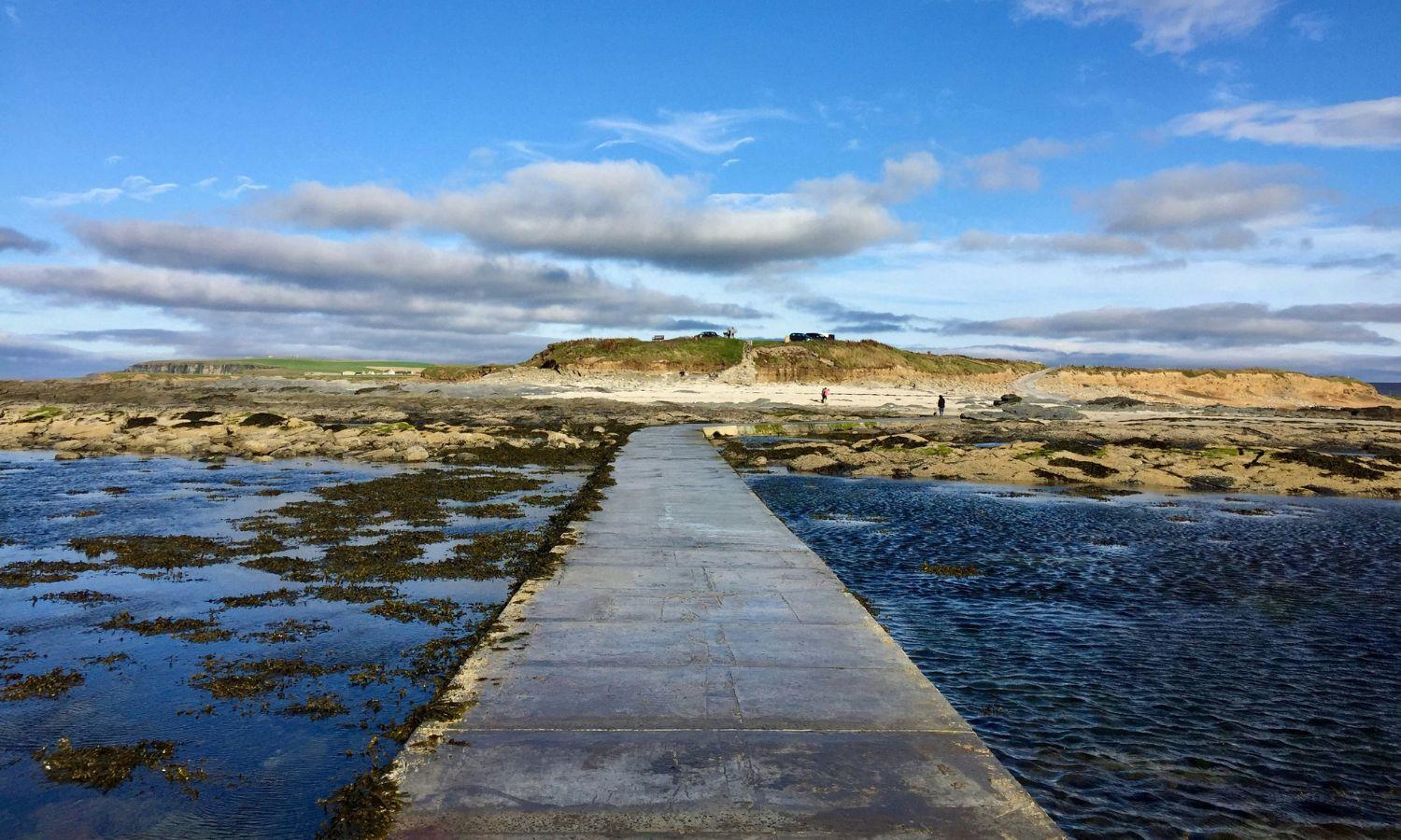 Walkway to idyllic island in Orkney on a sunny day