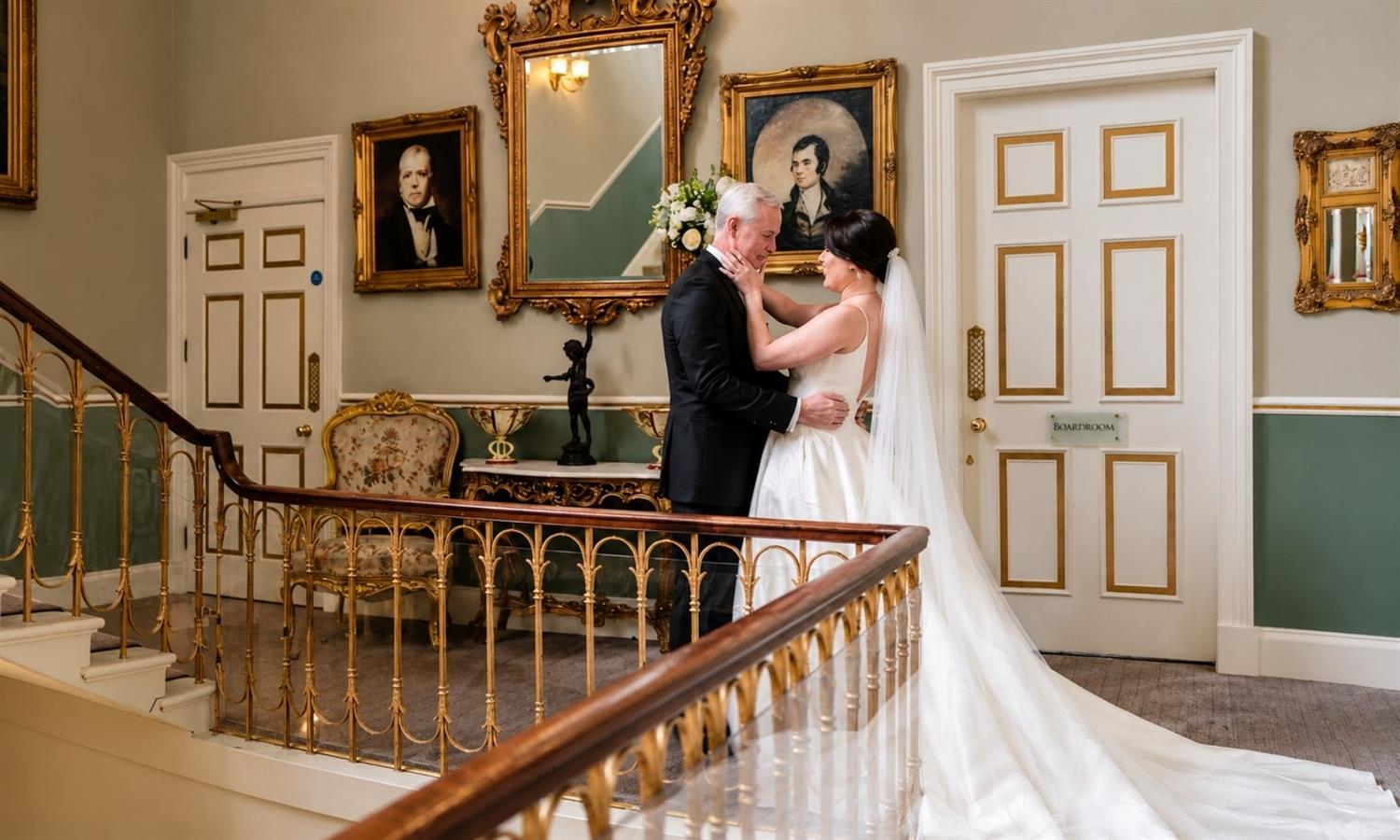 Newlyweds in the stairway looking in love at Melville Castle