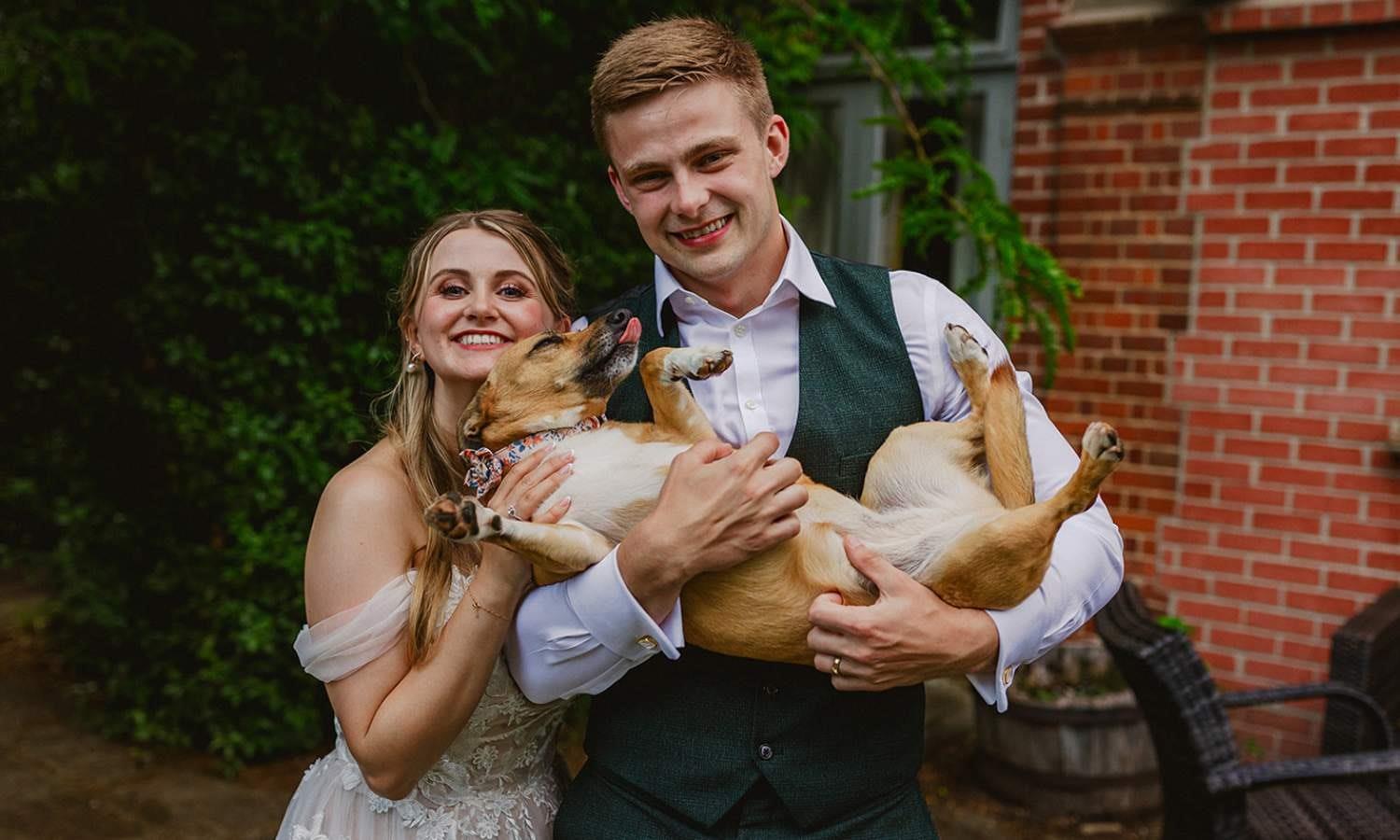 Bride & Groom carry their dog like a baby