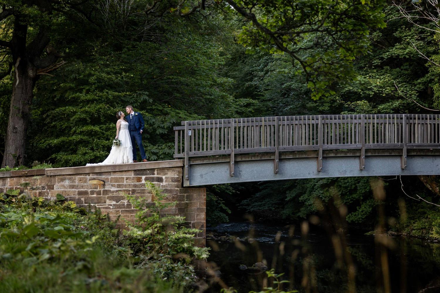 Wedding couple on bridge in the grounds of Melville Castle