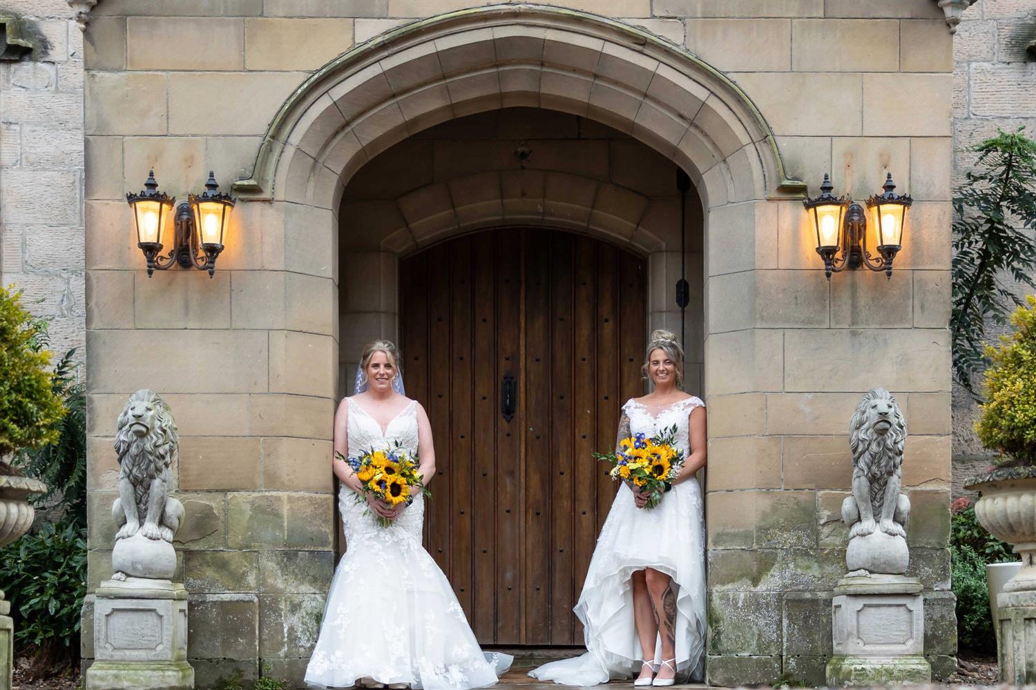 Two brides standing by castle's door