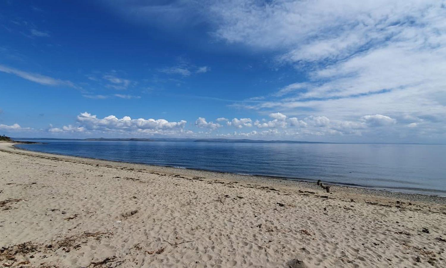 Sandy beach with very still sea on a sunny day
