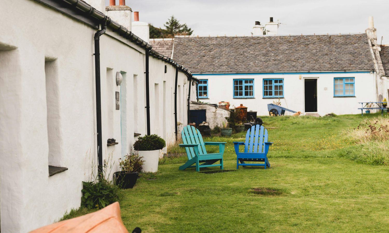 Exterior of self-catering cottages with sun chairs outside