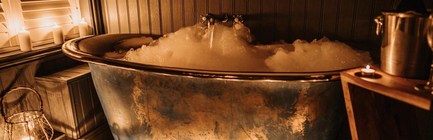 Metal bath with bubbles and candles