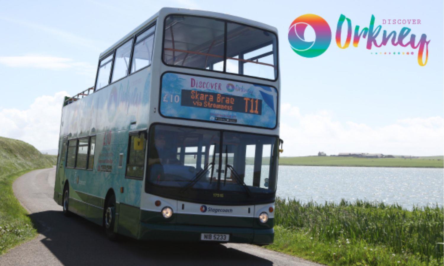 T11 open top bus driving on coastal road in Orkney