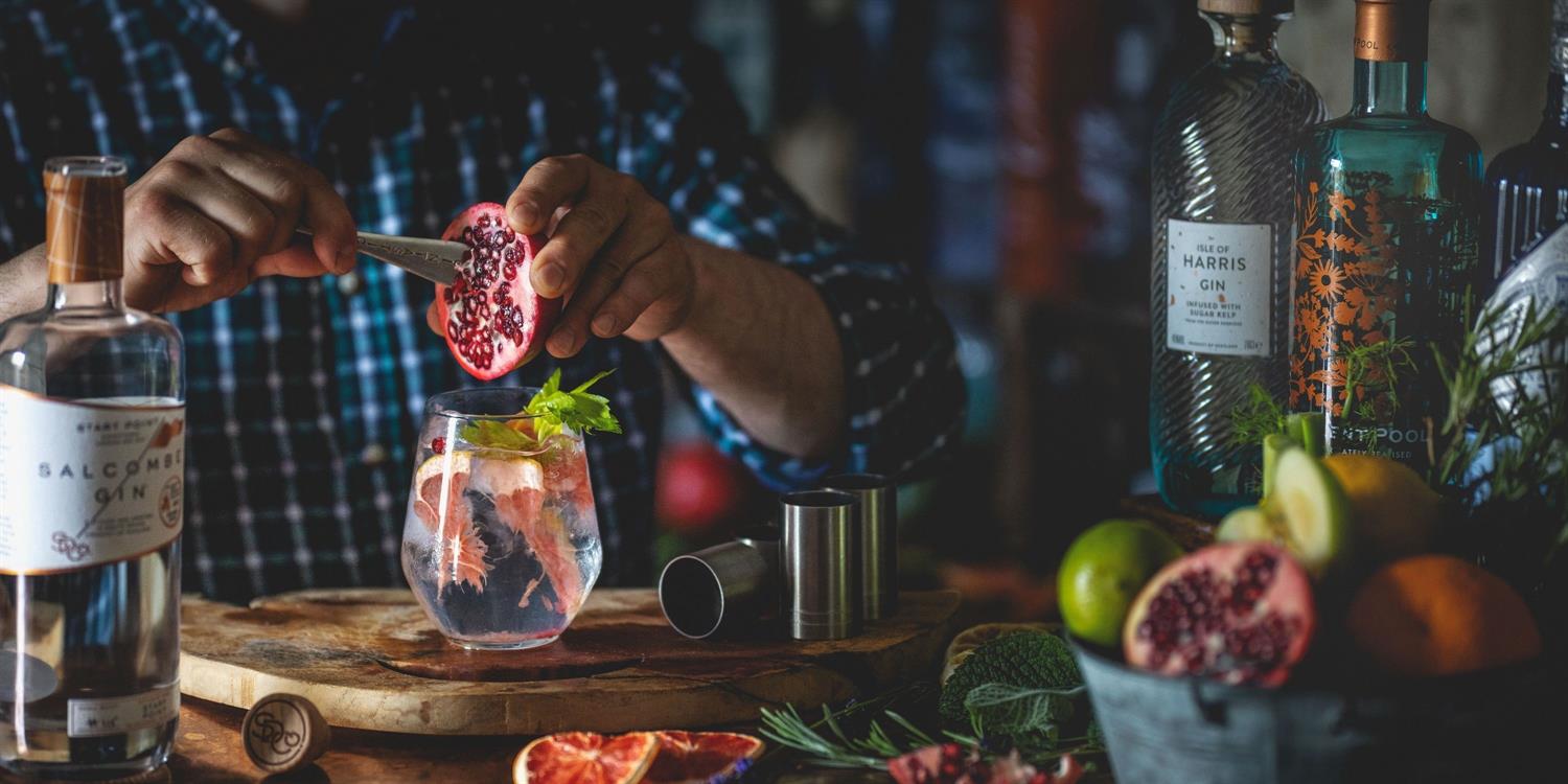 Pomegranate being sliced and put into a cocktail glass