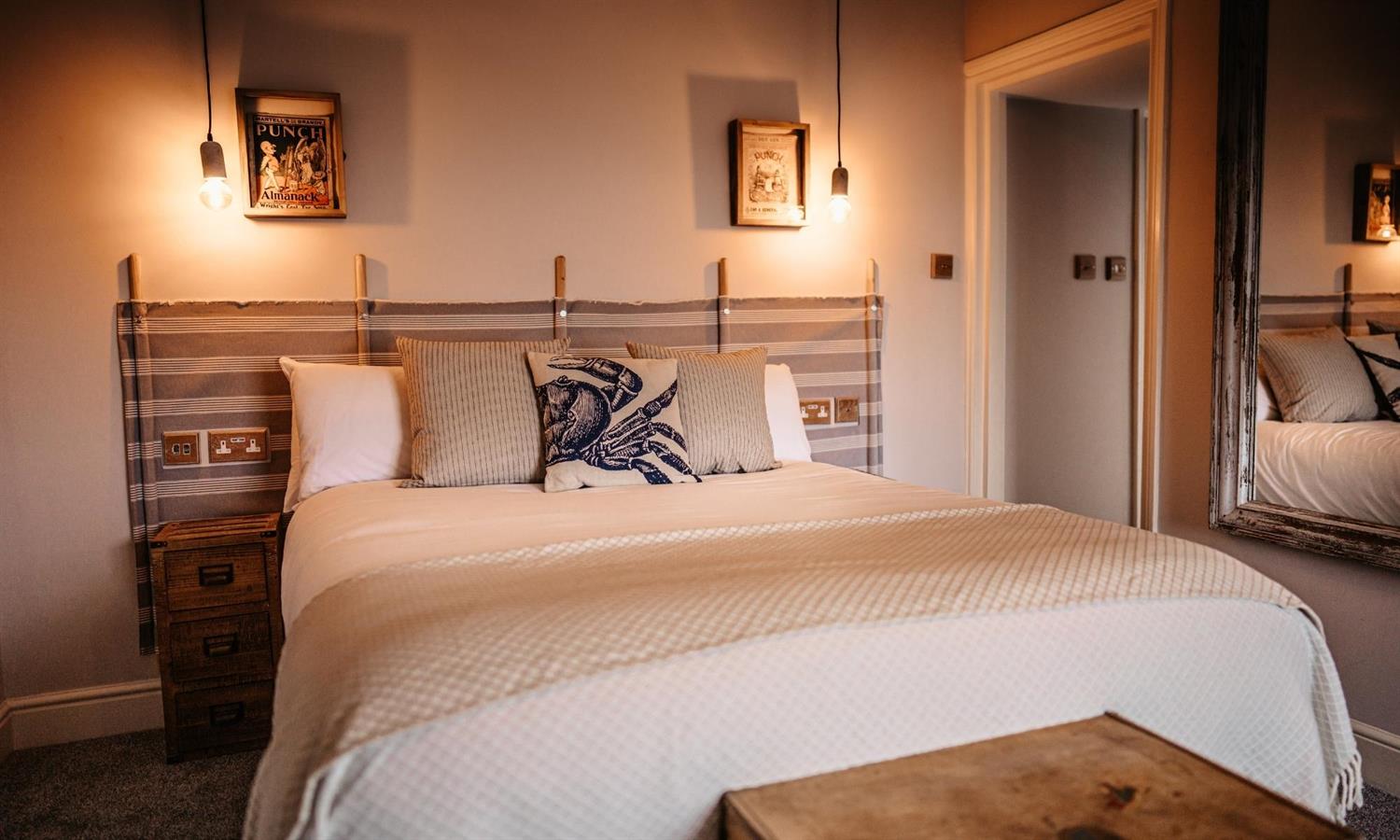 Double bedroom at Ship Inn hotel with cushions and windbreaker headboard