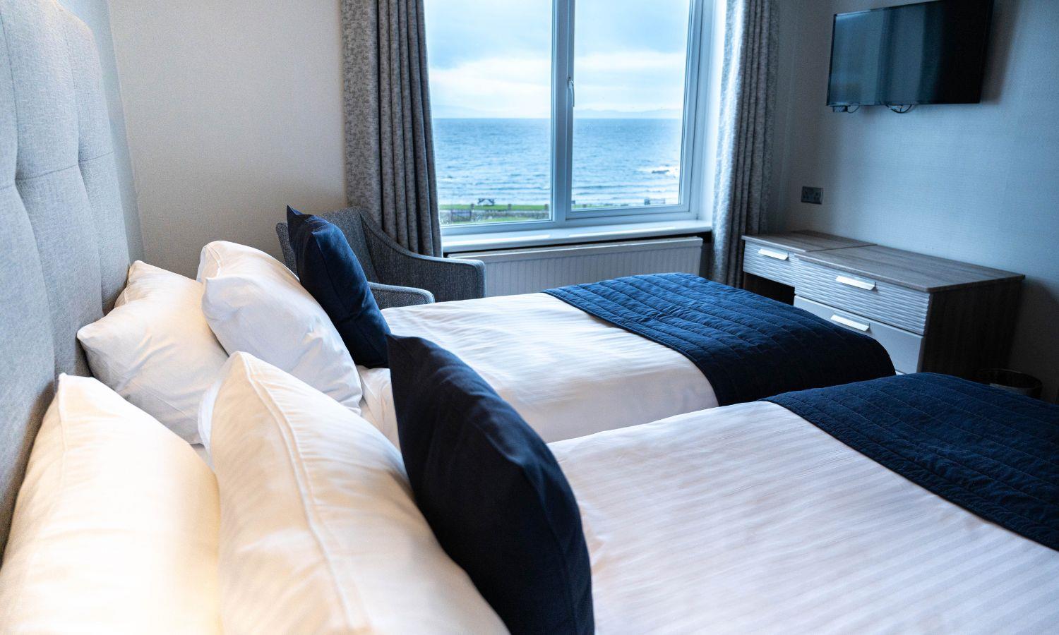 Hotel bedroom with sea view and two single beds in twin formation