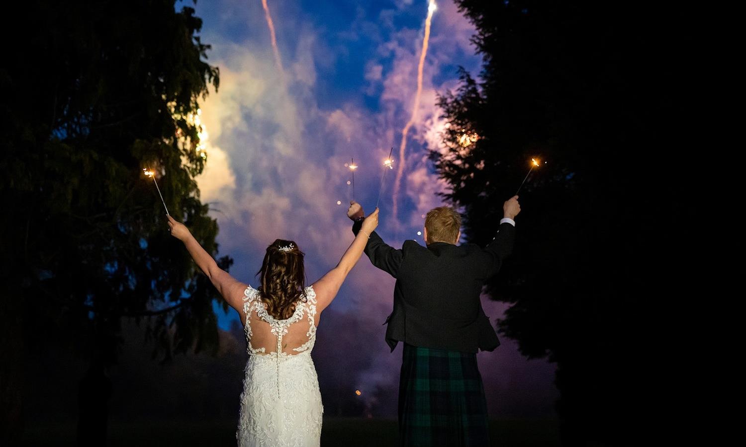 Bride and groom celebrating with fireworks & sparklers