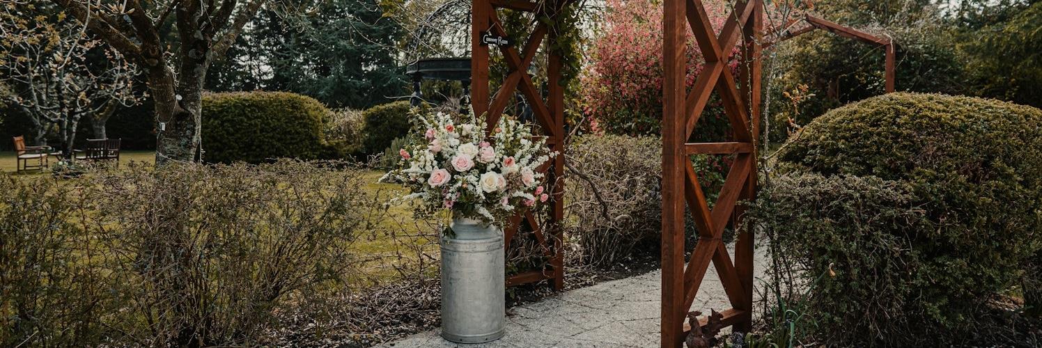 Widbrook Grange's garden with a milk churn full of flowers