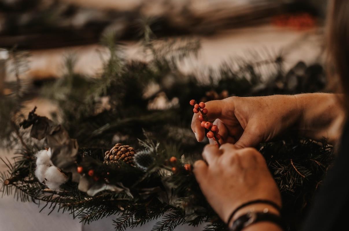 A womans hand making her own christmas wreath 