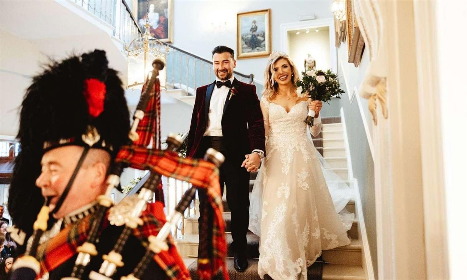 Bride and groom with Scottish piper
