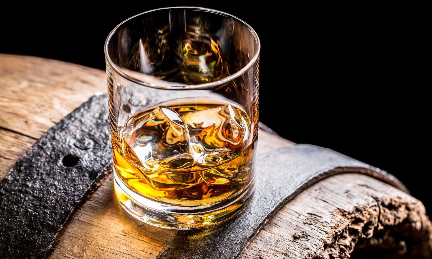 Dram of whisky balanced on a whisky cask