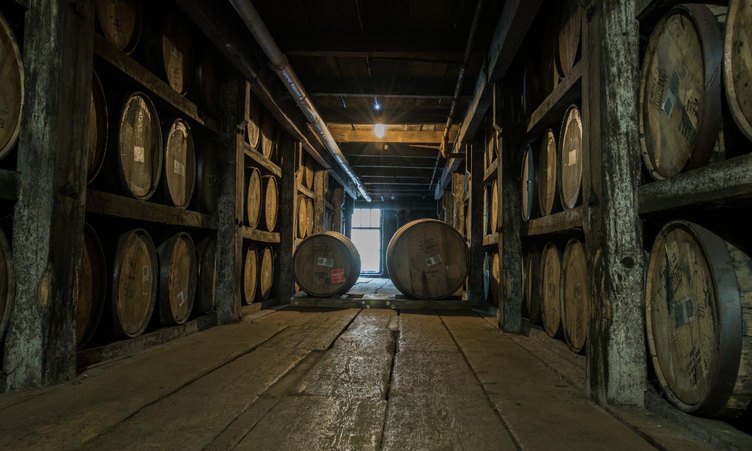 Whisky barrels on shelving in distillery