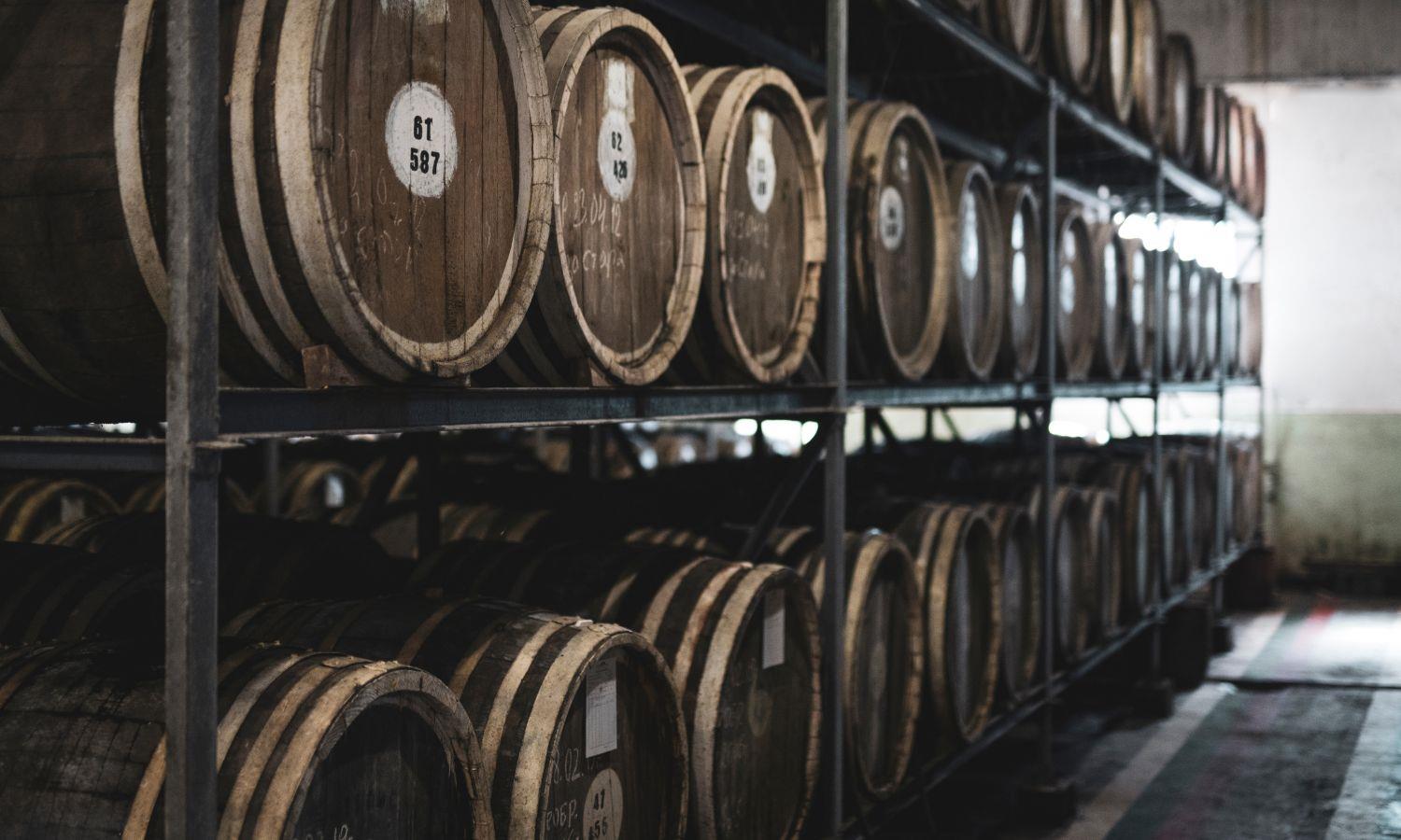 Whisky barrels on shelving in distillery