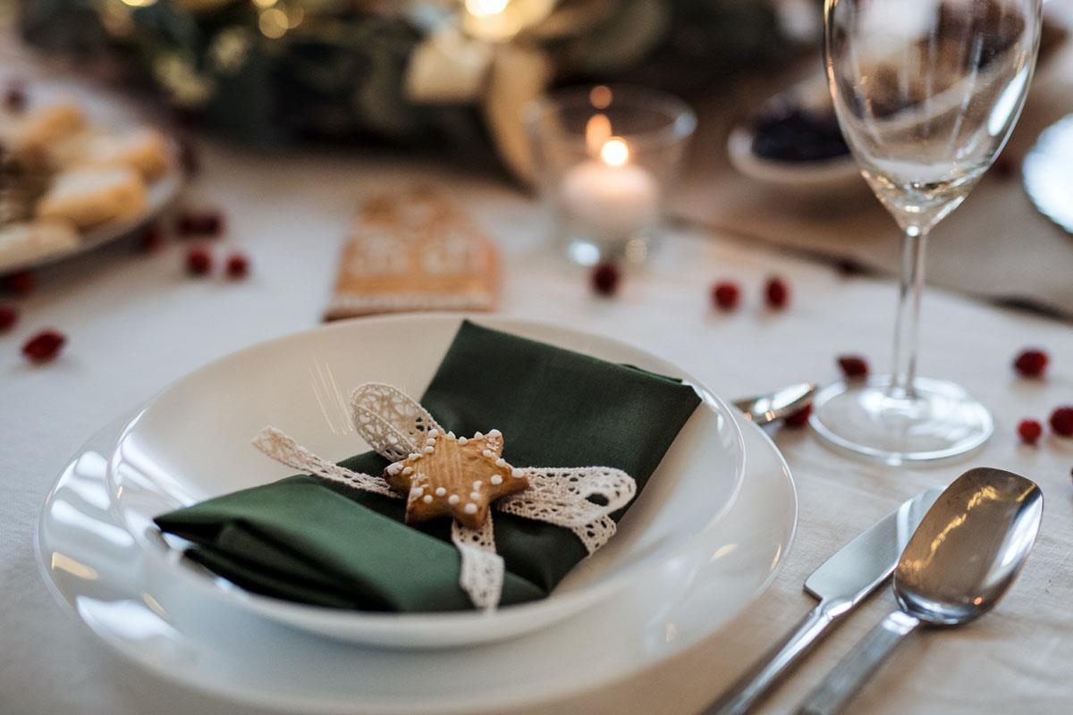 Green serviette and star shortbread on a table laid for Christmas meal 