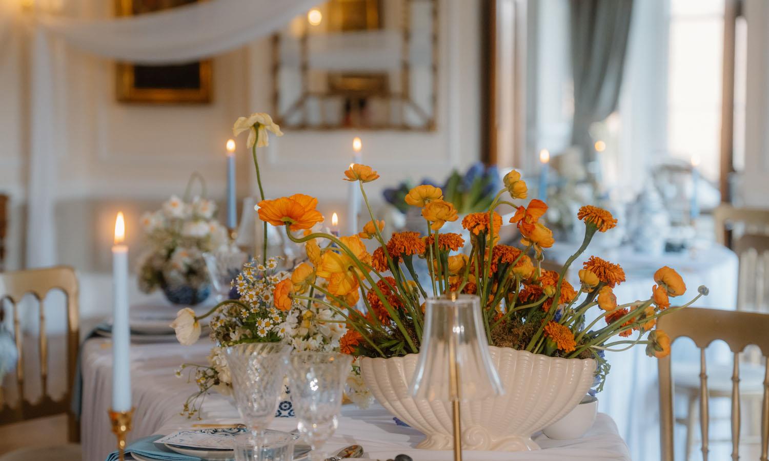Orange flower decoration on table with candles