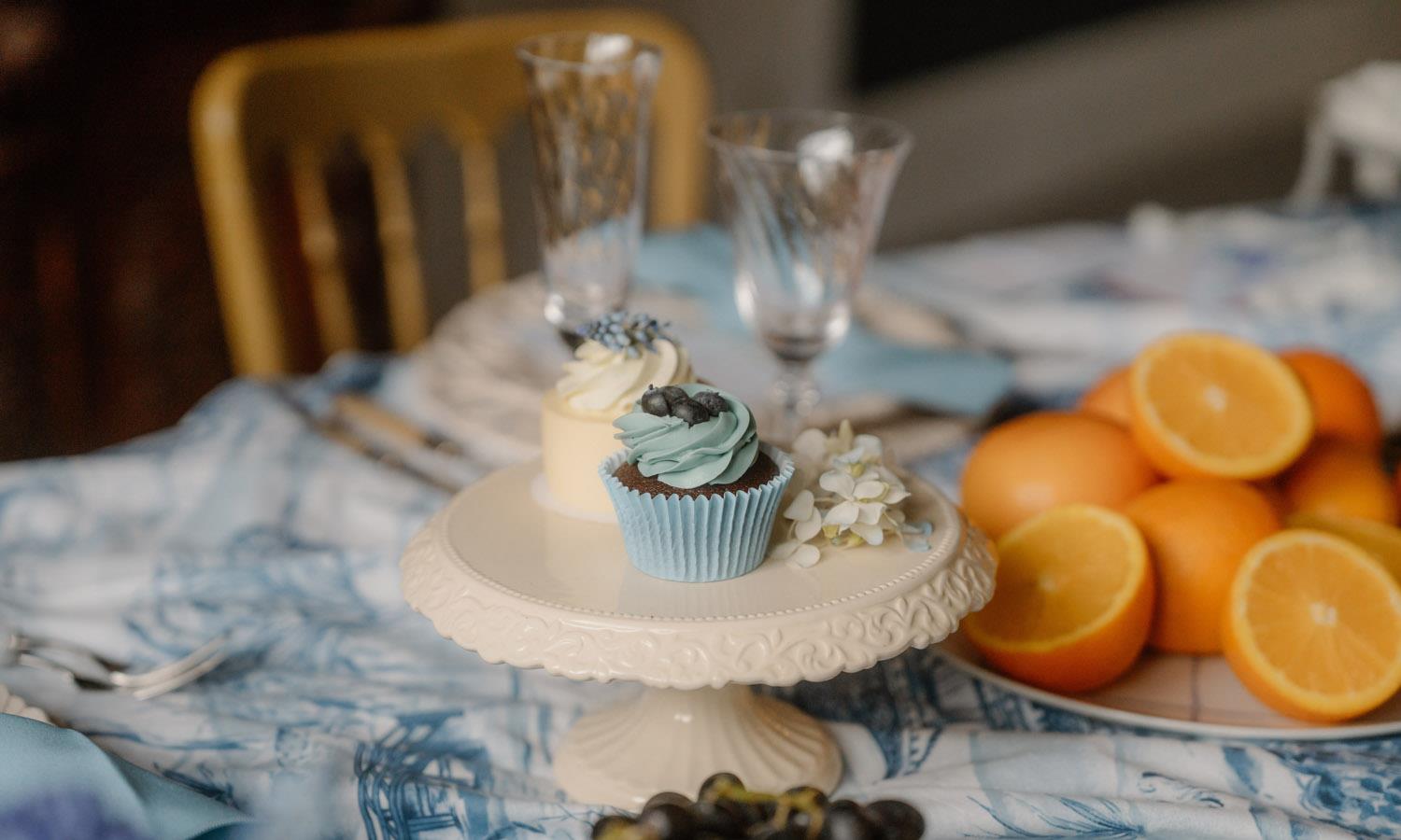 fairy cakes on stand next to oranges