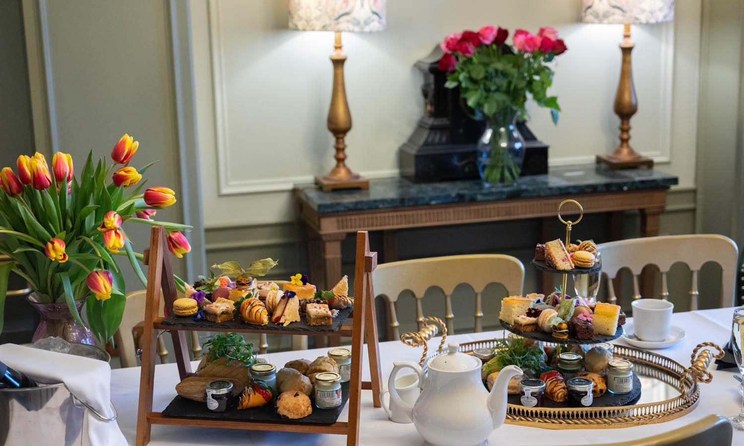 Afternoon tea on wooden stands on a table at Auchen Castle