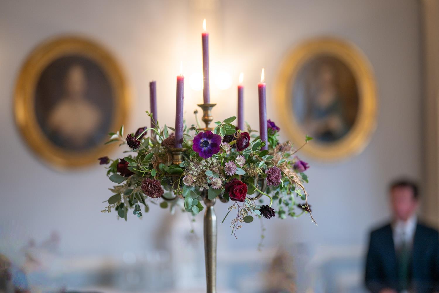 A candle centrepiece framed by two portraits 