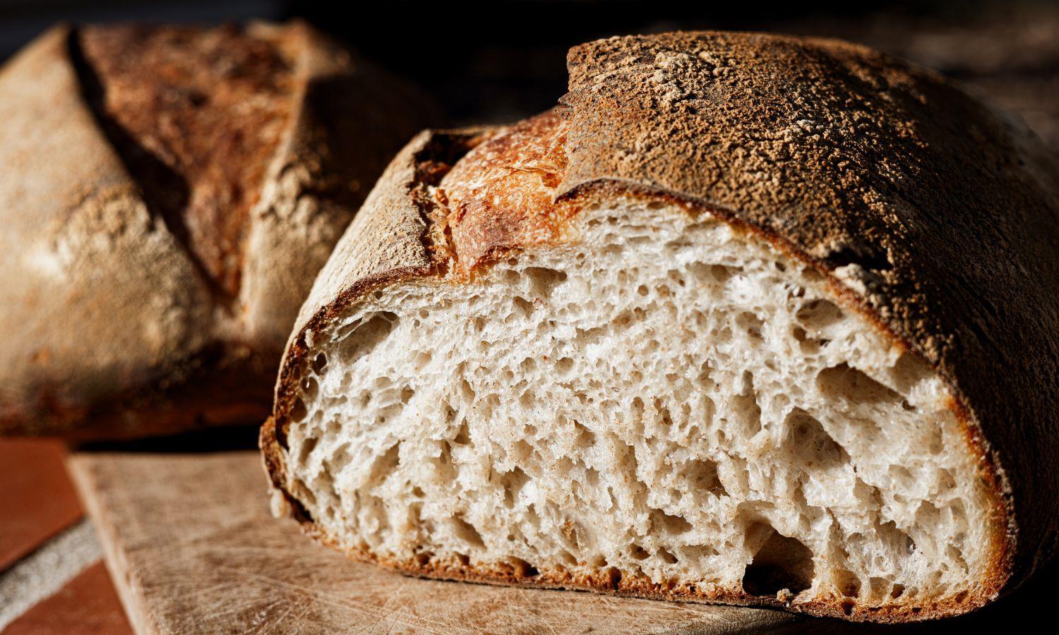 Freshly baked sourdough bread cut open to reveal perfect rise