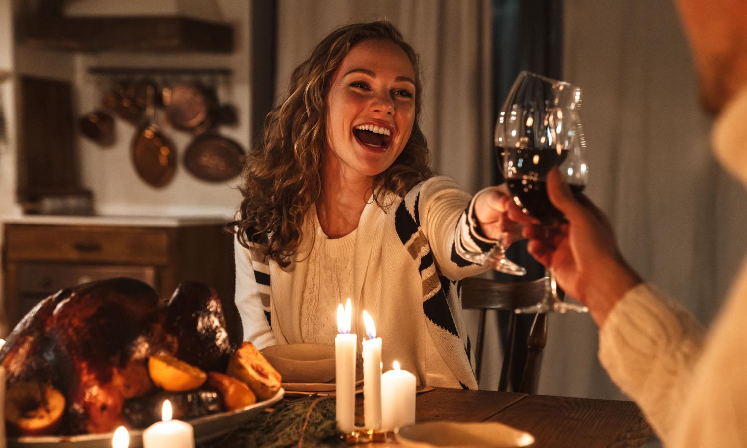 Couple performing a champagne toast over a roast turkey christmas meal