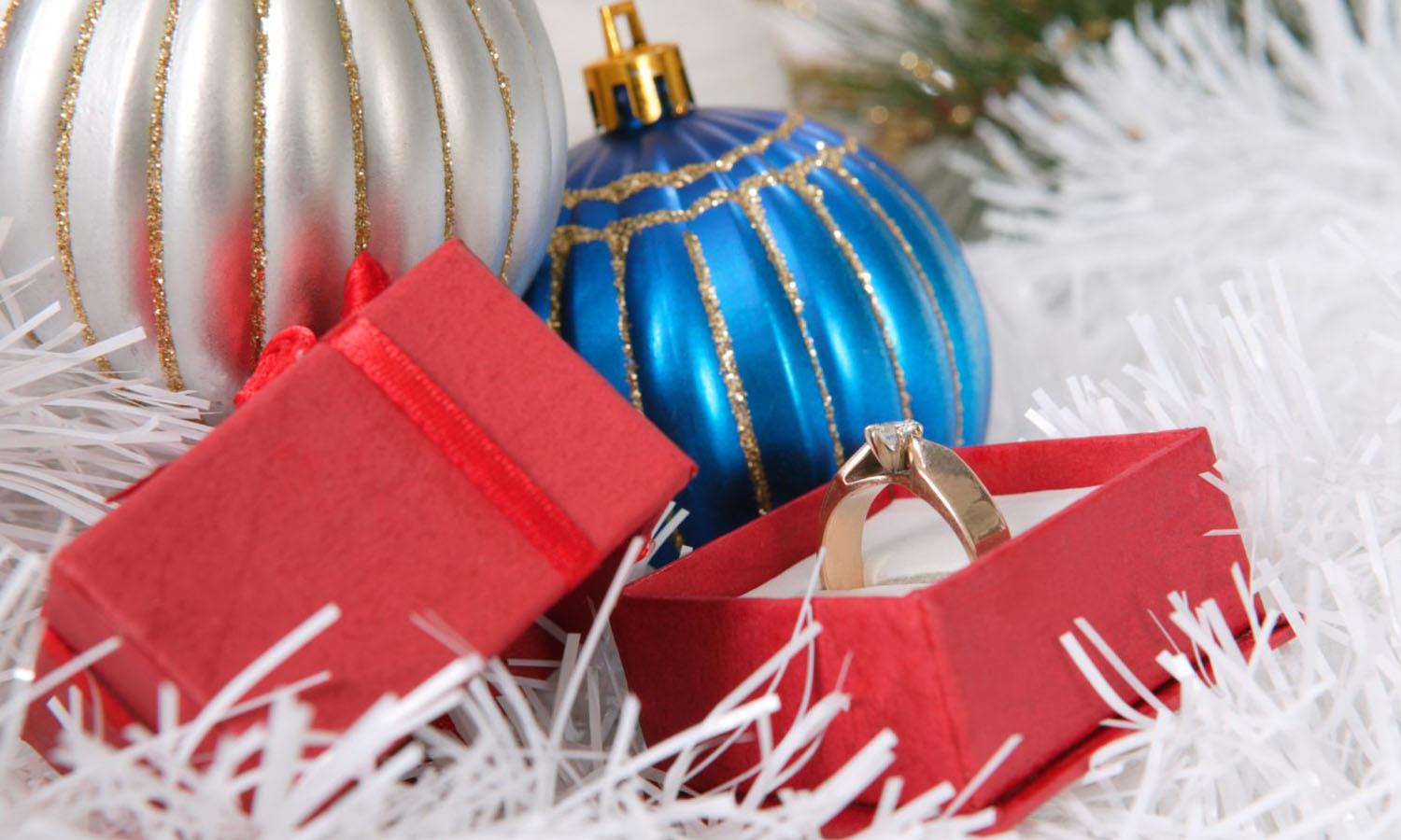 Engagement ring in box with Christmas baubles