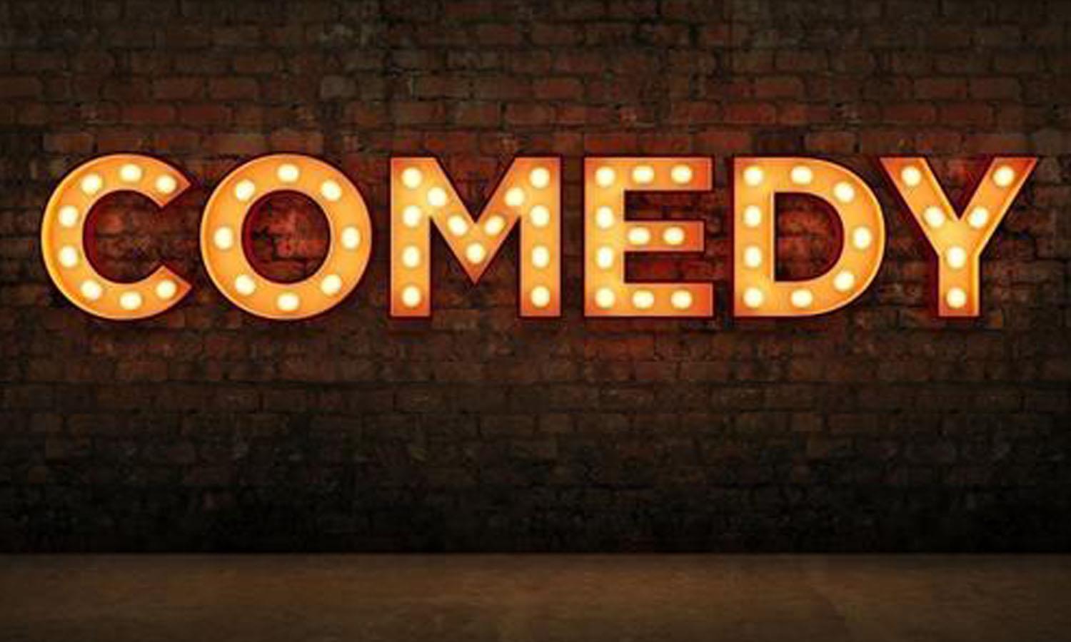 Neon sign reading 'comedy'