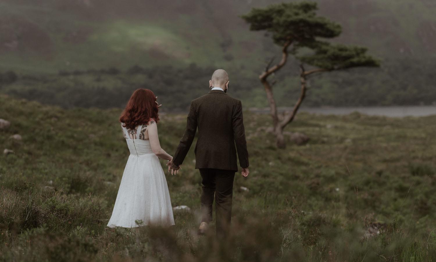 Wedded couple walking on highland heath
