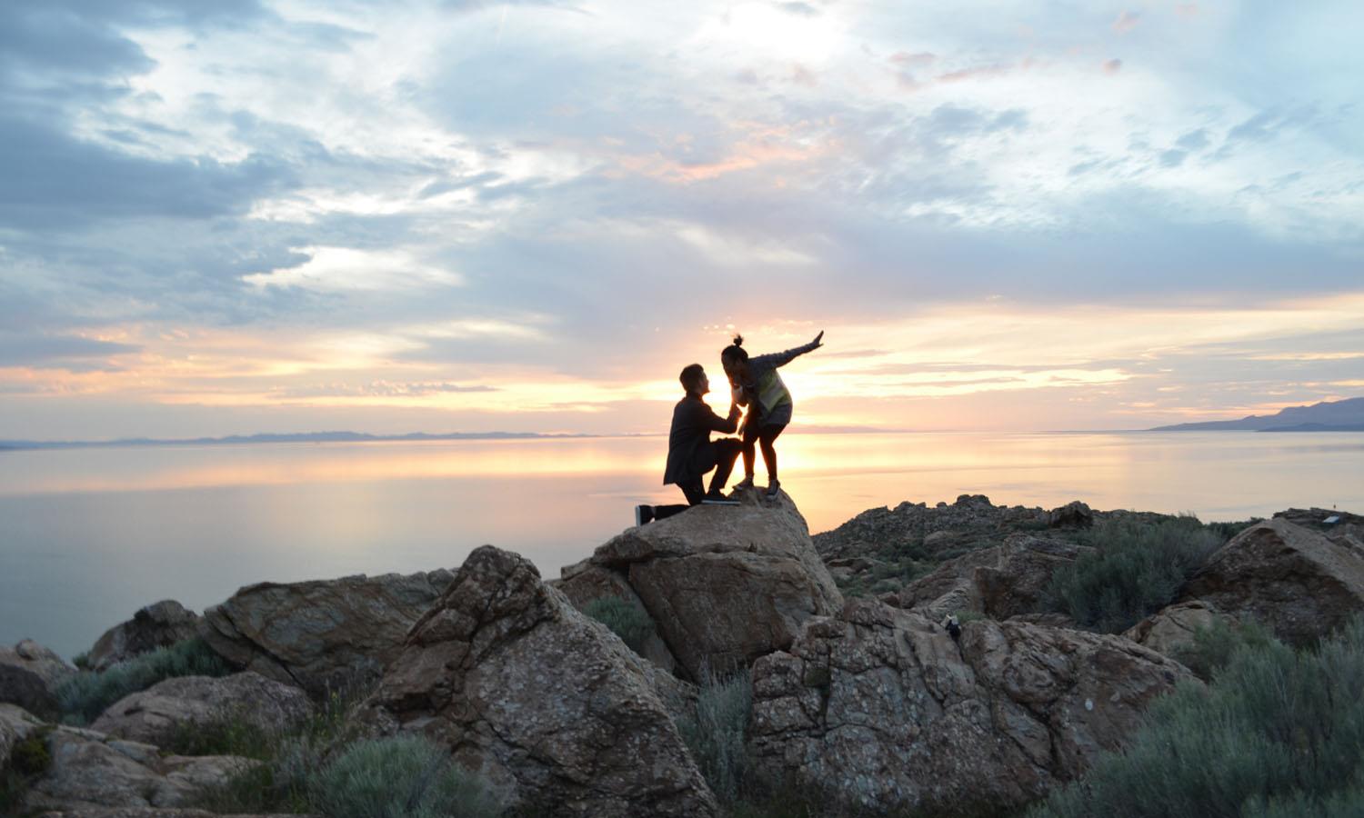 2 people on rocks at sunset