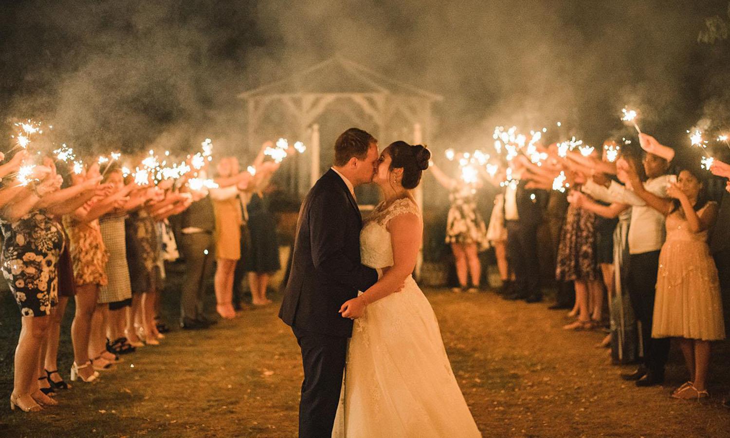 Bride & Groom kiss surrounded by sparklers in our private garden, of The Elephant wedding venue