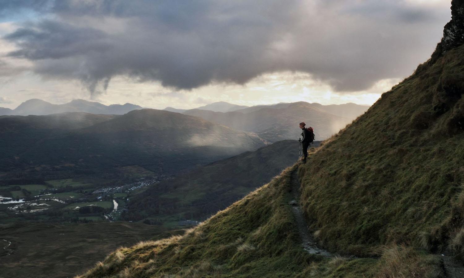 Hiker looking walking down mountainside