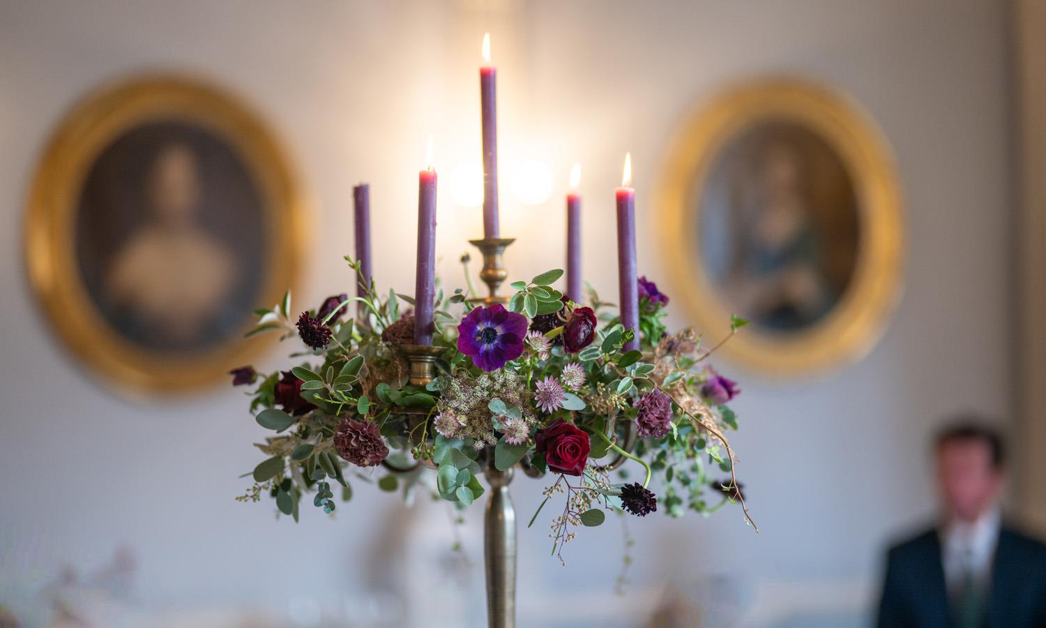A candle centrepiece framed by two portraits 