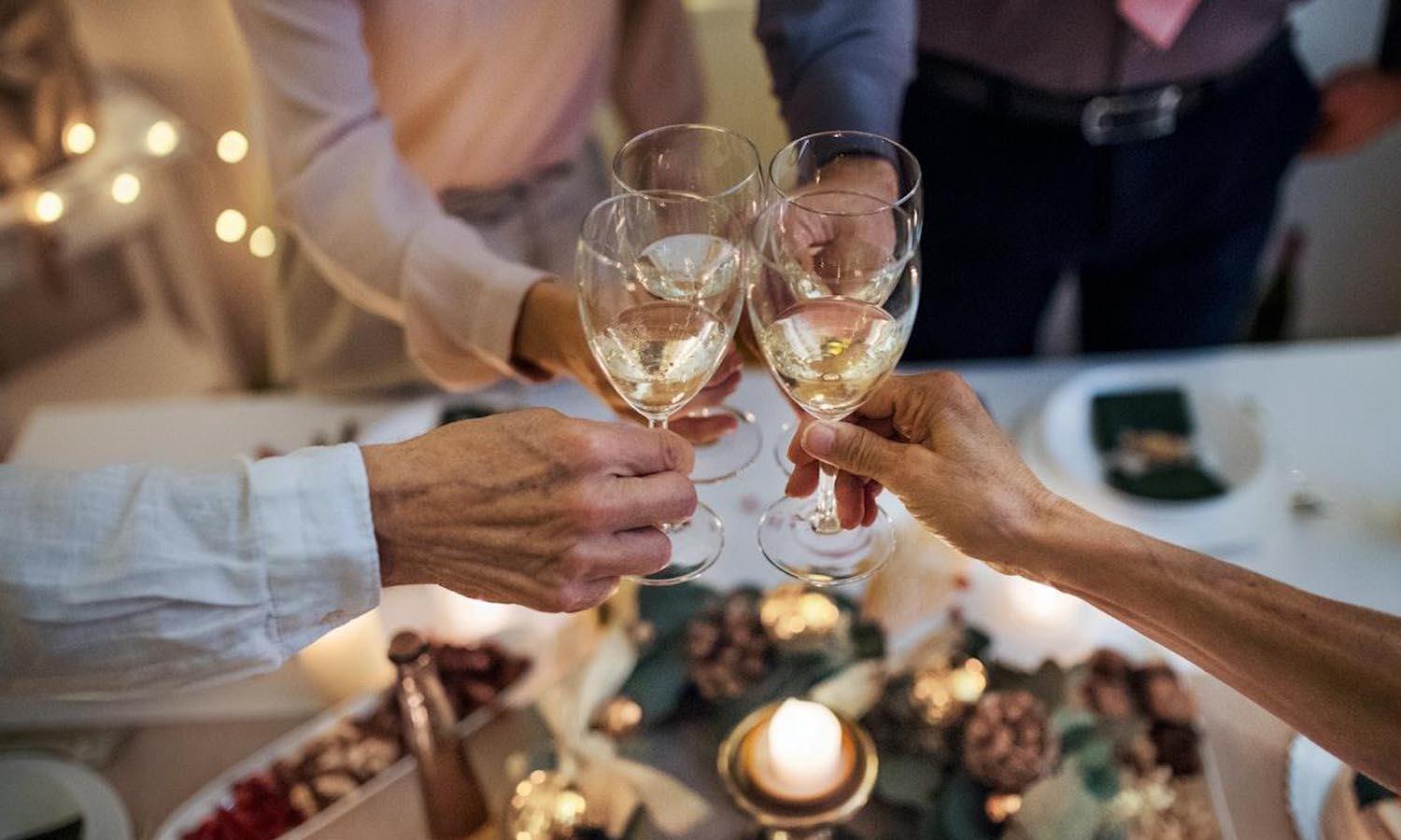 Three glasses being clinked together at a party
