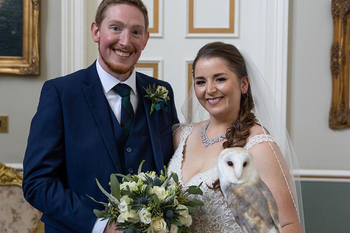 Wedding couple with bride holding owl and bouquet
