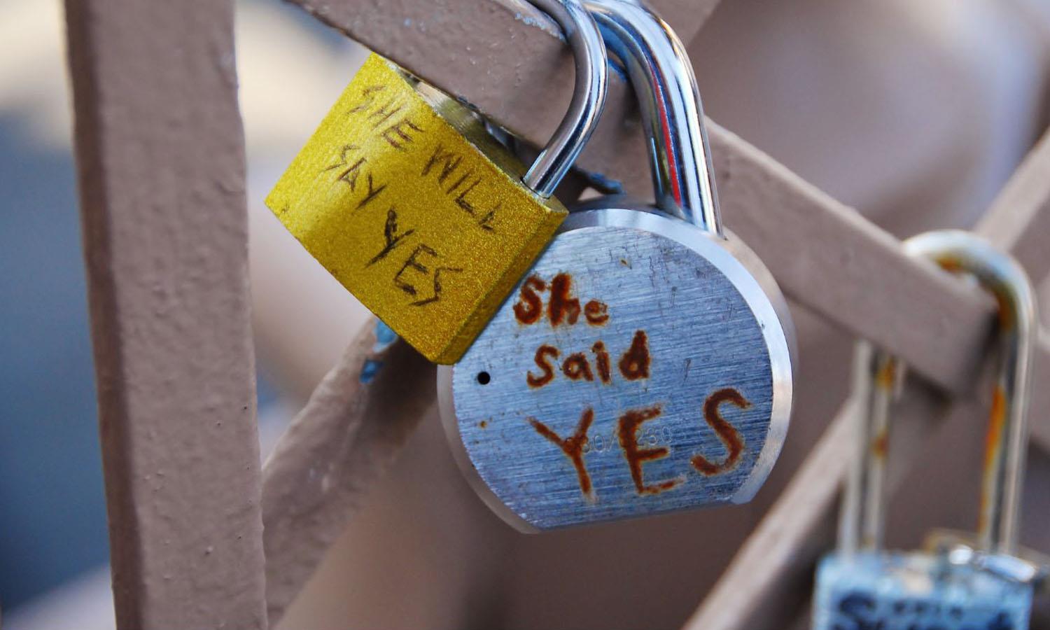 Padlocks saying she said yes on a fence