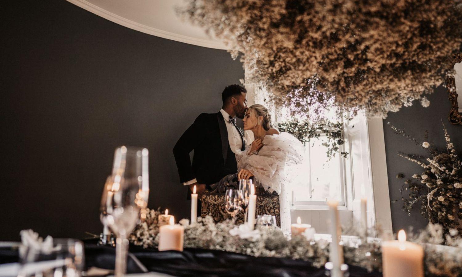 Newlywed couple in castle turret ceremony room with candles and flowers