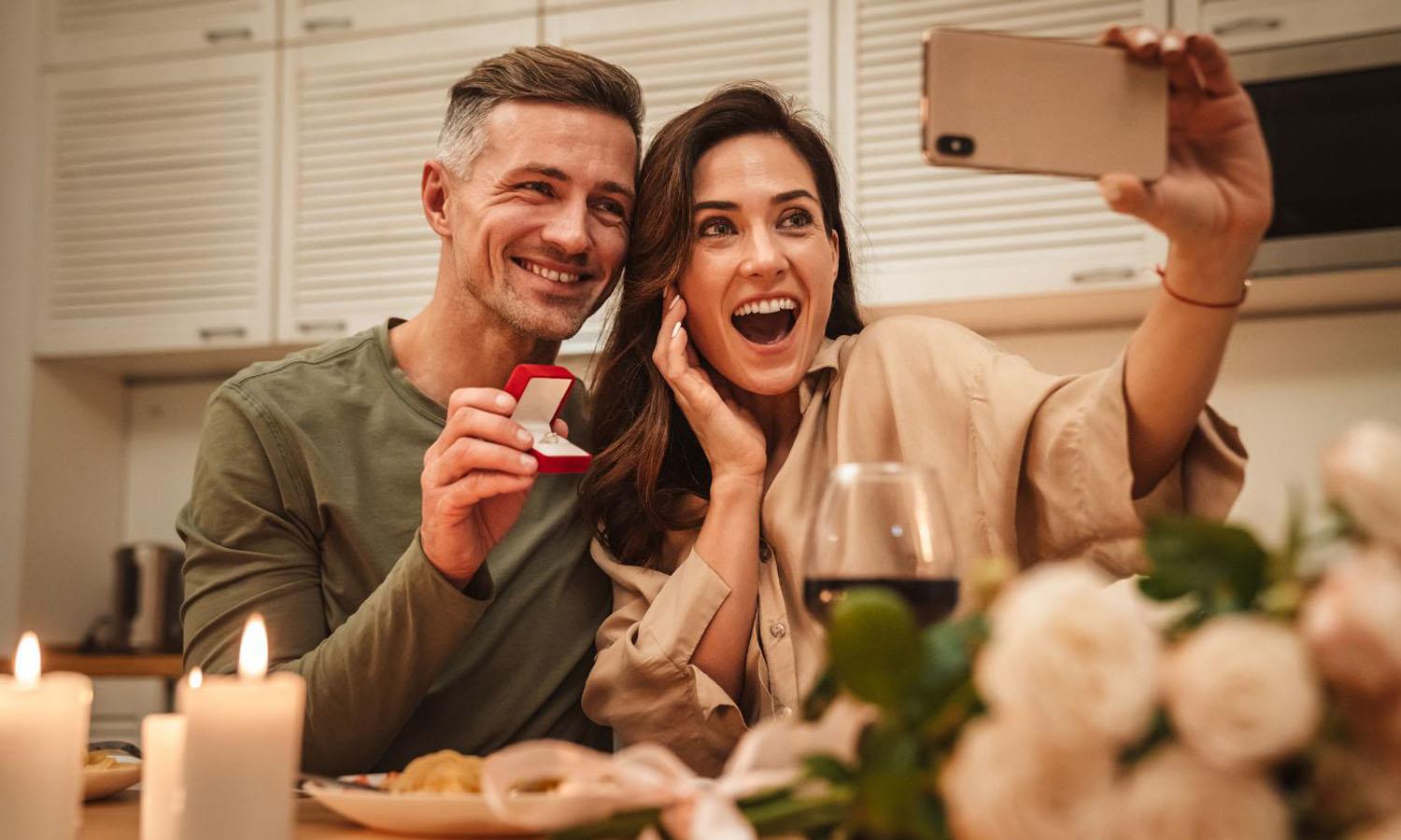 Woman taking selfie of her and boyfriend with engagement ring