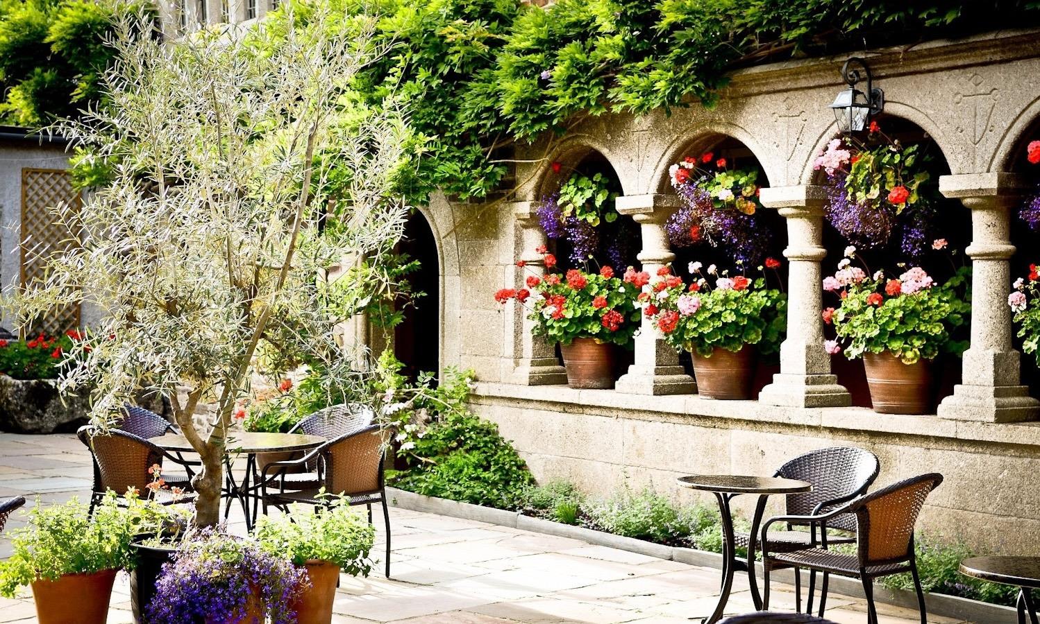 Lewtrenchard Manor's courtyard, filled with plants and trees. 