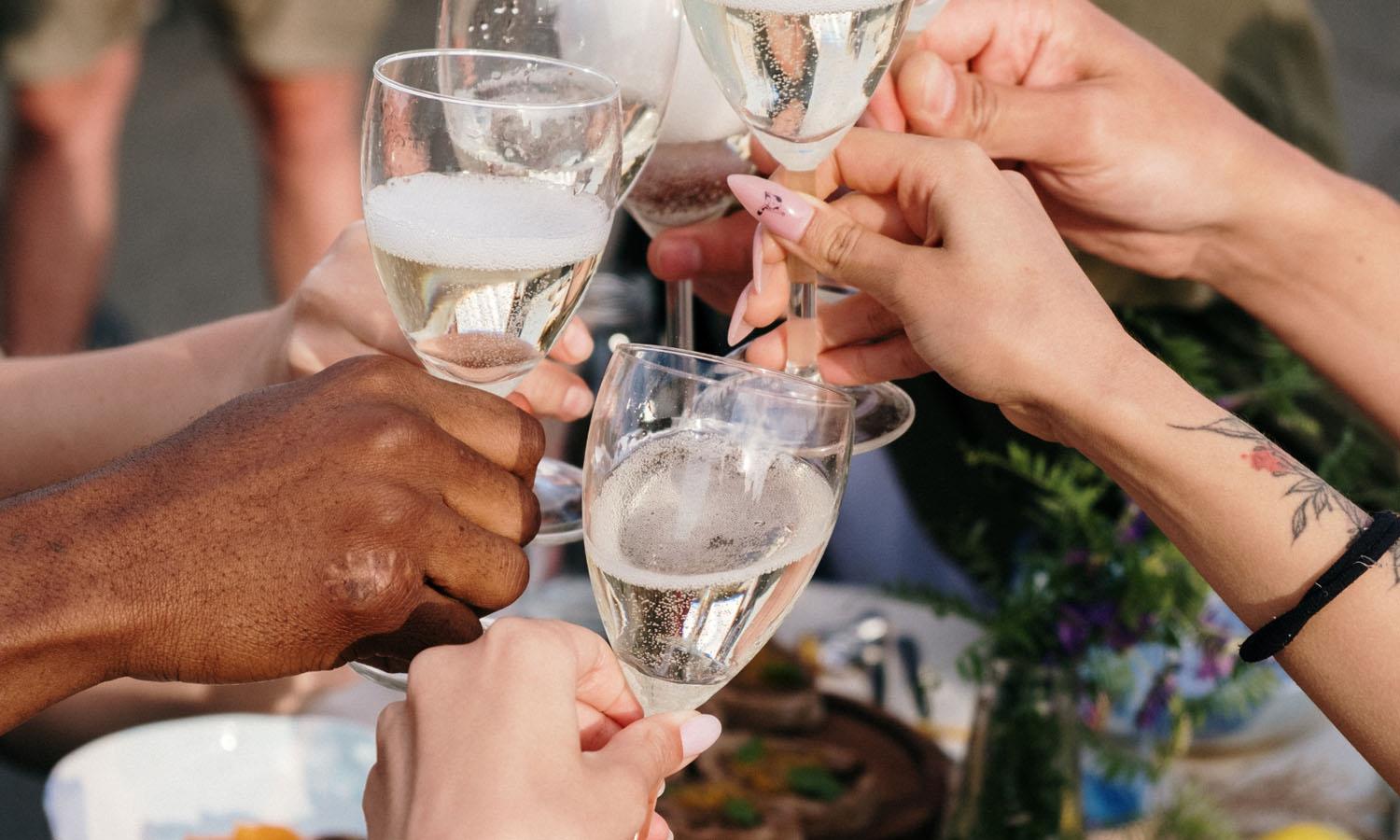 Hands clinking together glasses of champagne