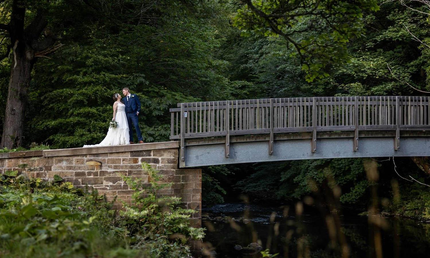 Wedding couple on bridge in the grounds of Melville Castle