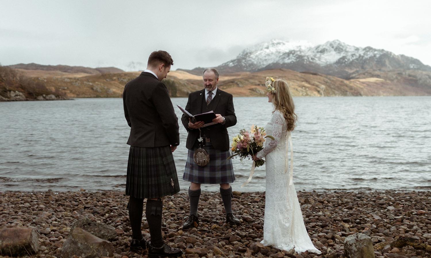 Couple marrying on edge of loch at Shieldaig Lodge Hotel